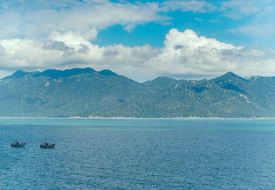 Scenic view of sea and mountains against sky