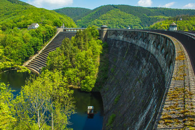 Arch bridge over river against mountains