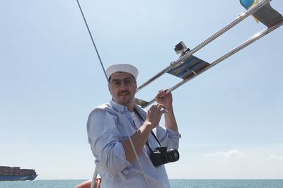 Man standing by sea against sky