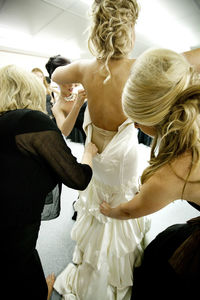 Friends dressing up bride