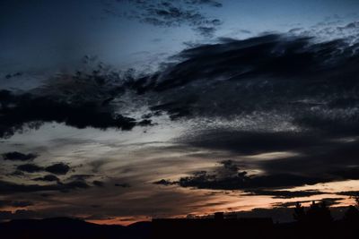 Low angle view of storm clouds at sunset