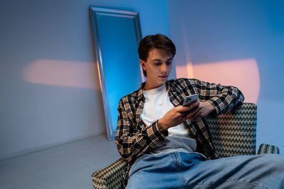 Young man sitting on sofa at home