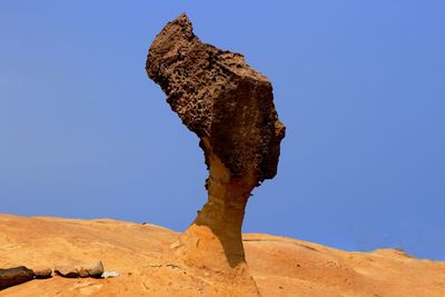 Rock formation in desert against clear blue sky