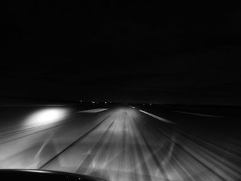 Road seen through car windshield at night