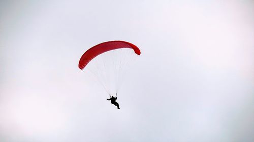 Low angle view of person paragliding against clear sky