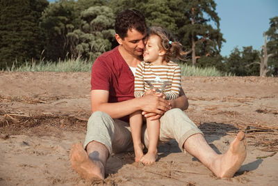 Happy friends sitting on land