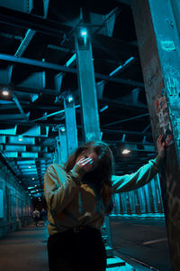 Rear view of young woman standing in train