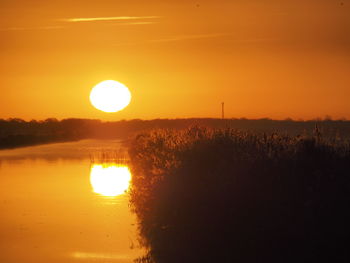 Scenic view of silhouette landscape against orange sky