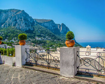 Built structure against plants and mountains against clear blue sky