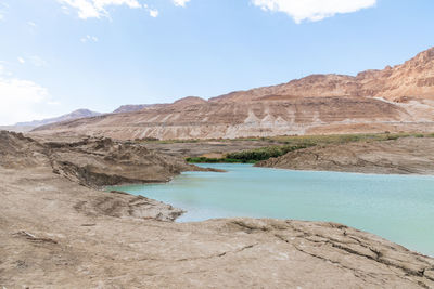 Sinkhole filled with turquoise water, near dead sea coastline. hole formed when underground salt is