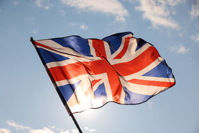 Uk great britain national flag flying and waving in the wind, backlit in golden hour