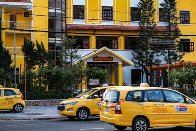Cars on road by buildings in city