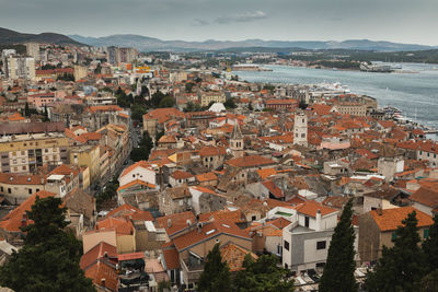 High angle view of town by sea against sky