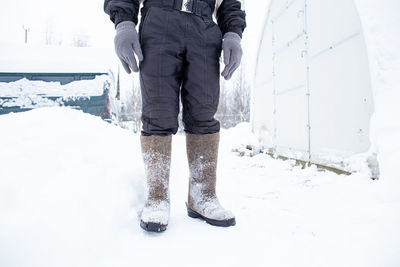 Low section of person standing on snow covered land