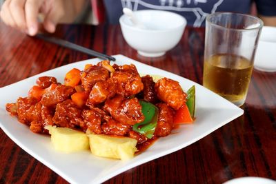Close-up of hand holding food served on table