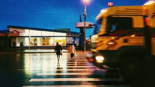 People in illuminated city at night