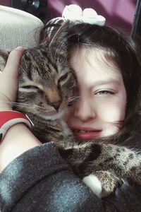 Close-up portrait of girl embracing cat