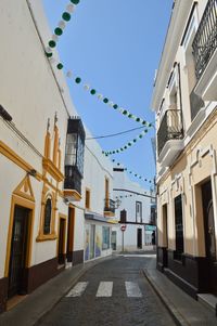 Street amidst buildings against sky in city