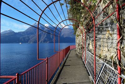 Empty bridge by sea against sky