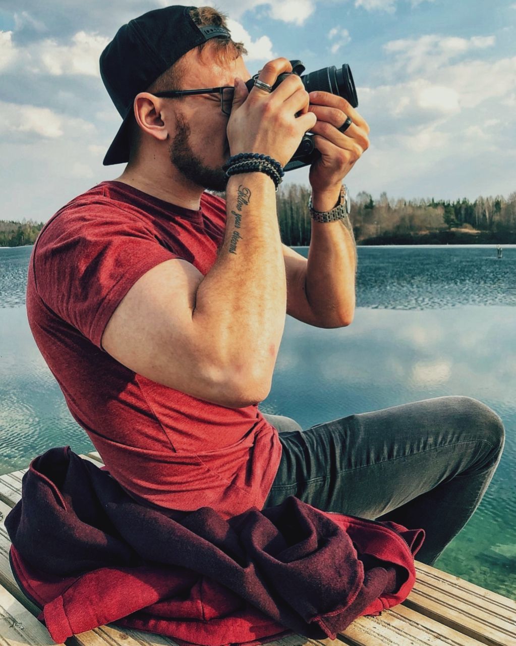 water, real people, one person, young men, leisure activity, lake, young adult, lifestyles, sitting, casual clothing, nature, holding, day, sky, men, glasses, outdoors, drinking