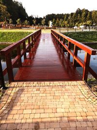 Empty footpath in park against sky