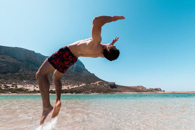 Man surfing in sea against clear sky