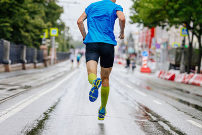 Low section of man running on road