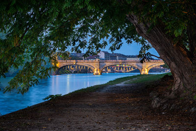 Bridge over river against sky at night