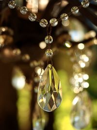 Close-up of illuminated chandelier with hanging crystals