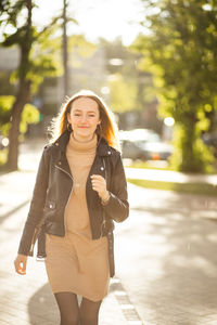 Portrait of young woman standing in city