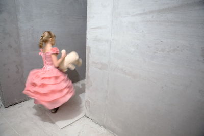 Rear view of girl sitting on floor