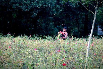 Women sitting on grass against trees