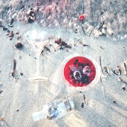 High angle view of drink in wineglass on wet shore