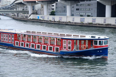 Boats in river against buildings in city