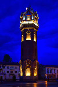 Low angle view of clock tower against sky at night