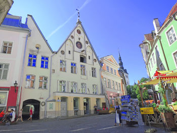 Street amidst buildings in city against clear blue sky