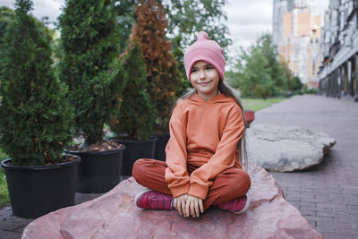 Portrait of smiling girl sitting outdoors