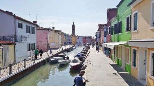 Canal amidst buildings in city against sky