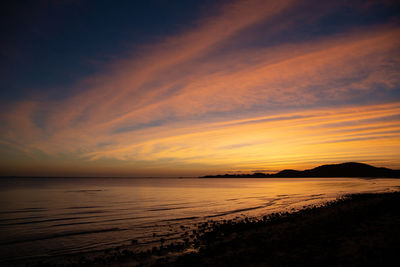 Scenic view of sea against romantic sky at sunset