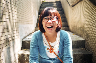 Portrait of happy mid adult woman sitting on steps