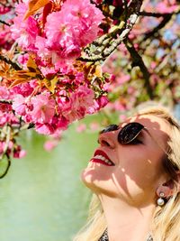 Close-up of woman with pink flower on tree