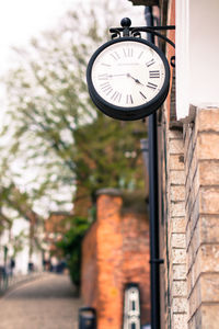 Low angle view of clock by buildings against sky