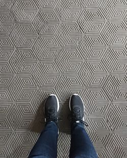 Low section of man standing on tiled floor