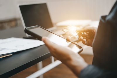 Midsection of man using mobile phone