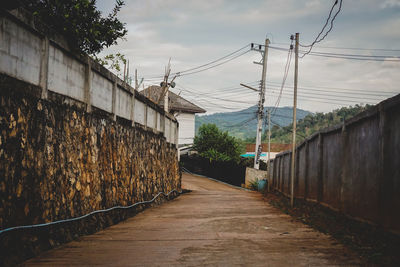 Street amidst trees against sky