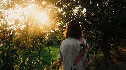 Rear view of woman standing on field