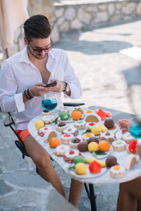 Handsome guy using smart phone on a terrace in summertime.