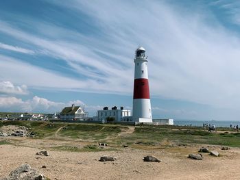 Portland bill lighthouse by sea against lightly clouded sky and sea 