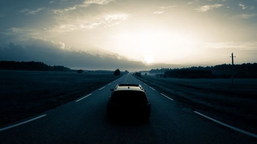 Car on road against sky during sunset