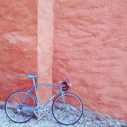 Bicycle parked against brick wall